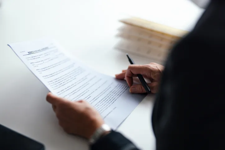 Close-up of business leader and counsel reviewing a contract